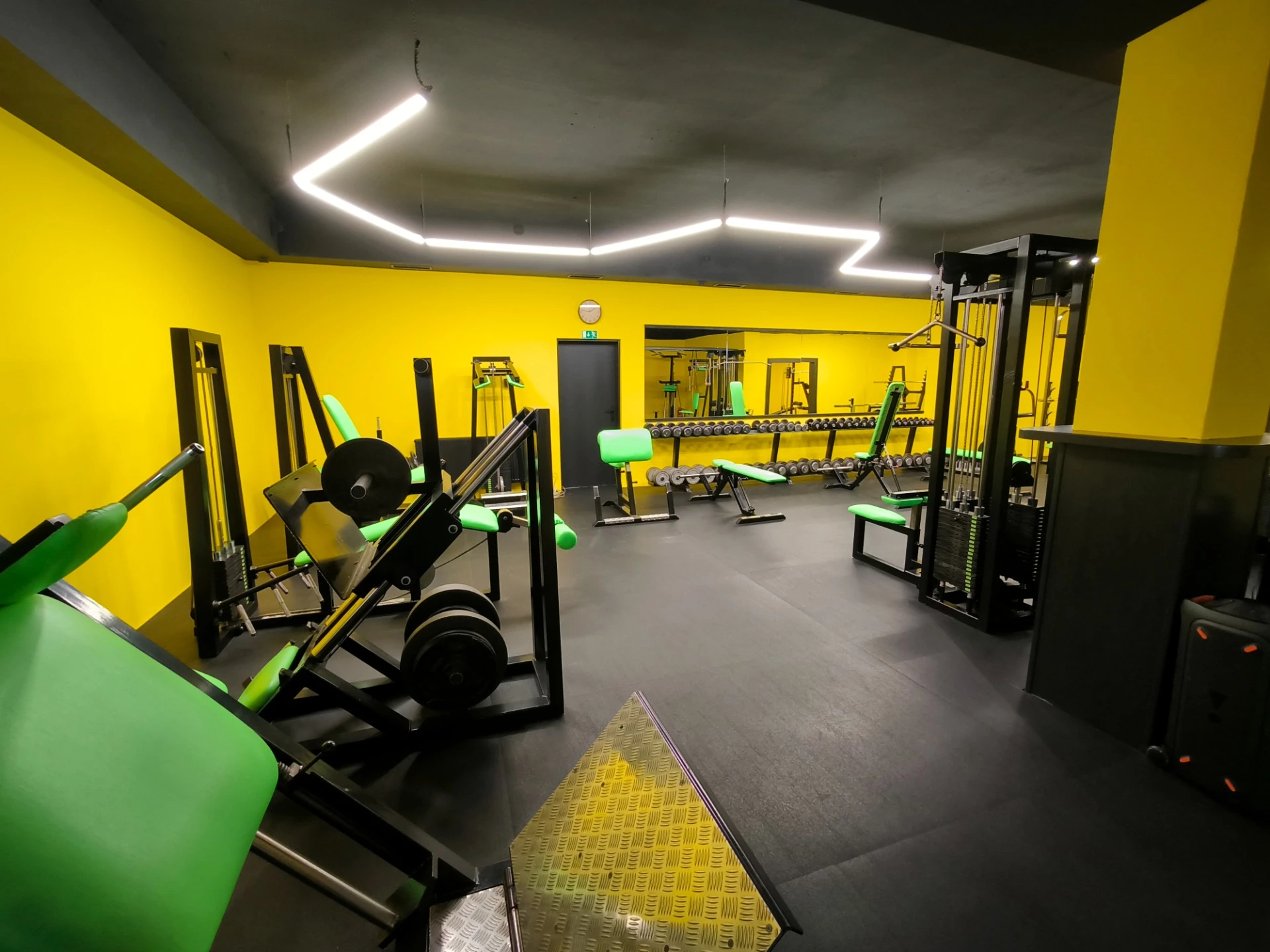 Posilovací stroje v černožlutém Uran Gymu